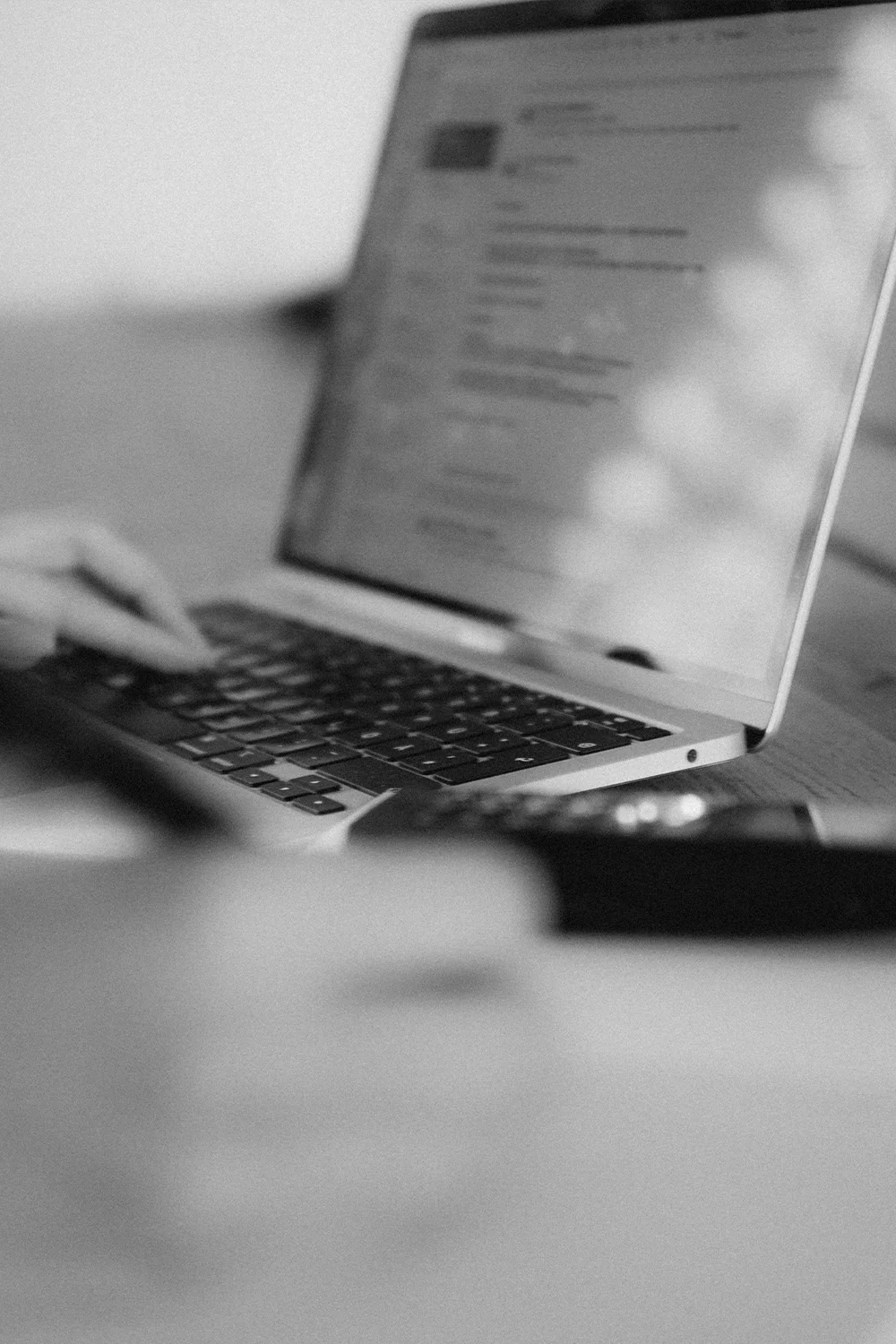 Nahaufnahme eines geöffneten Laptops. Der beleuchtete Bildschirm mit Text steht im Fokus, während der unscharfe Vordergrund die Intimität des Arbeitsprozesses betont.